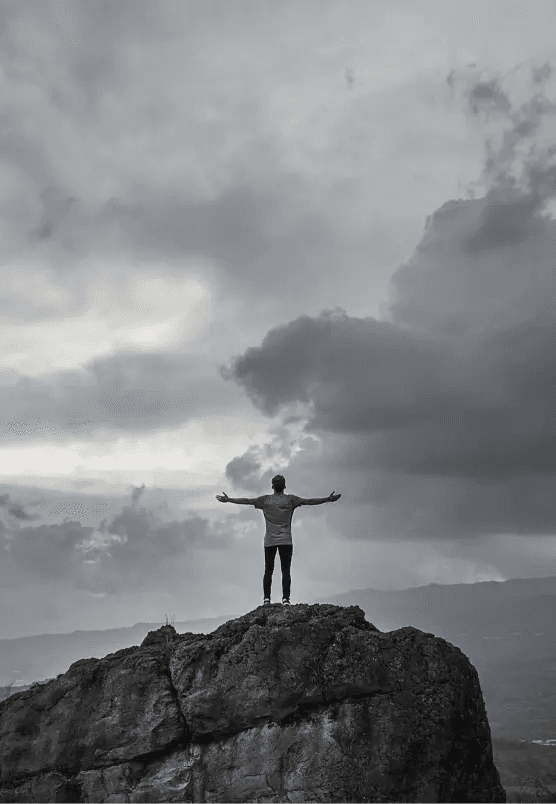 Mężczyzna rozkładający ręce na urwisku