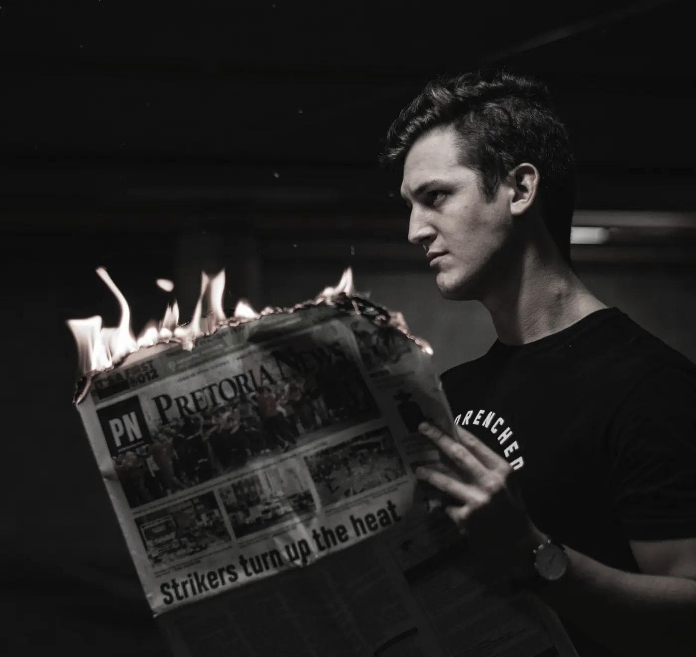 Skupiony mężczyzna palący gazetę